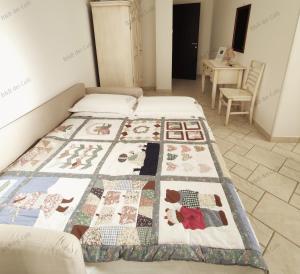 a bed with a quilt on it in a bedroom at Bed & Breakfast dei Colli in Ostuni