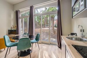 a kitchen with a table and chairs and a large window at Au Loft de Fauriel cosy terrasse in Saint-Étienne