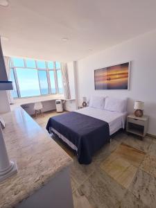 1 dormitorio con 1 cama grande con manta azul en Leme ao Pontal, en Río de Janeiro