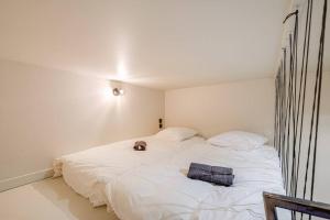 a white bed with a stuffed animal sitting on it at Au Loft de Fauriel cosy terrasse in Saint-Étienne