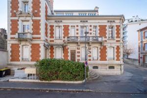 a large brick building with a balcony on a street at Au Loft de Fauriel cosy terrasse in Saint-Étienne