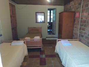 a room with two beds and a brick wall at Casa El Encuentro in San Carlos de Bolívar +19 photos