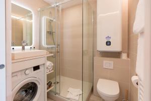 a bathroom with a toilet and a sink and a washing machine at Atlantic Selection - La Parenthèse de Capbreton - Vue océan, plage Notre-Dame in Capbreton
