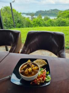 a plate of food with a bowl of soup and vegetables at Mzinga Retreat in Gitesi