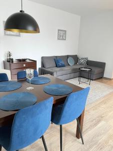 a living room with a table and blue chairs at Apartament Kalina in Lublin