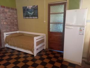 a small room with a bed and a refrigerator at Casa El Encuentro in San Carlos de Bolívar