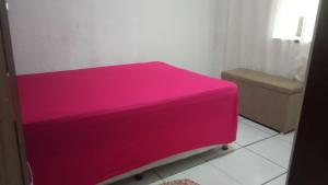 - un lit rose dans une chambre avec toilettes dans l'établissement CANTINHO DA ROMILDA, à Prado