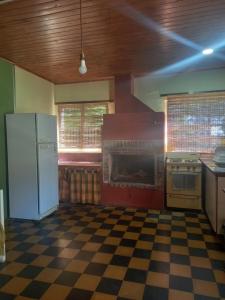 a kitchen with a white refrigerator and a checkered floor at Casa El Encuentro in San Carlos de Bolívar