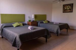 - une chambre avec 2 lits dans l'établissement Estancia Mixtecas, à León