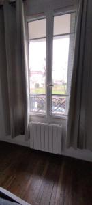 een lege kamer met twee ramen en een radiator bij Coquet 2 pièces proche de Paris in Bagnolet