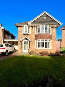 a brick house with a car parked in a yard at The Wizards House York - discounts for long stays in York