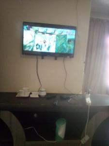 una TV a schermo piatto appesa a un muro di Nafi Guesthouse a Phuthaditjhaba