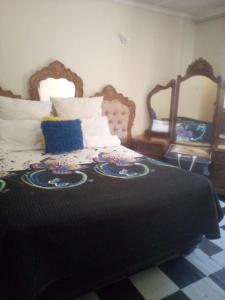 a bedroom with a bed with a black blanket on it at Nafi Guesthouse in Phuthaditjhaba