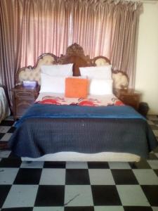 1 dormitorio con 1 cama grande con manta azul en Nafi Guesthouse, en Phuthaditjhaba