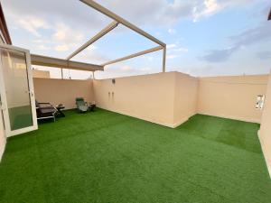 una stanza vuota con erba verde in un edificio di شقة العقيق عروة alaqeeq apartments a Medina