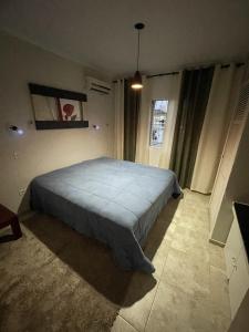 a bedroom with a large bed in a room at Quarto Duplo Costa brava in Guarujá