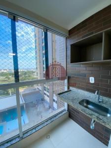 a kitchen with a sink and a large window at Piazza diRoma in Caldas Novas