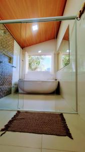 a bathroom with a bath tub and a window at Chalé Céu de Minas in Visconde De Maua