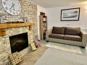 a living room with a couch and a clock on the wall at Chalet Charlotte in Fusch an der Glocknerstraße