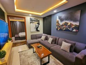 sala de estar con sofá y mesa en Gold Crest Mall One bedroom Penthouse Apartment DHA Lahore, en Lahore