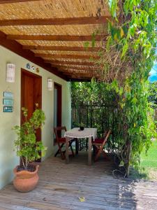 a patio with a table and chairs under a wooden ceiling at Morada das Marés in Arraial d'Ajuda