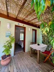 eine Terrasse mit einem Tisch und ein Zimmer mit einem Bett in der Unterkunft Morada das Marés in Arraial d'Ajuda