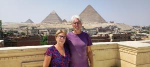 un homme et une femme se tenant devant les pyramides dans l'établissement YOYA pyramids KINGDOM view, au Caire
