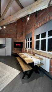 a room with a wooden table and a brick wall at Industrial Escape -Kelham Island in Sheffield