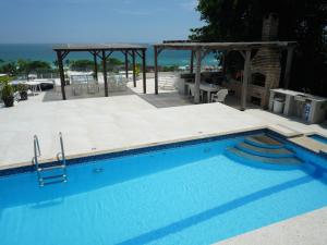 a swimming pool with a view of the ocean at Suites em Juquei in Juquei