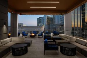 a lobby with couches and tables and a view of a city at AC Hotel by Marriott Raleigh North Hills in Raleigh