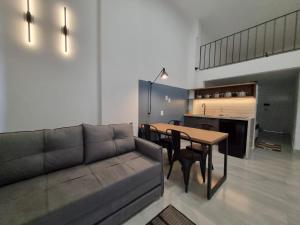 uma sala de estar com um sofá e uma mesa em LOFT MUNDI - Conforto no Centro com Ar Condicionado em Águas de Lindoia