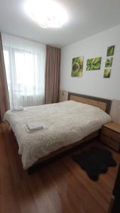 a bedroom with a large bed with white sheets and a window at VIP Apartment Belvedere Club in Bansko
