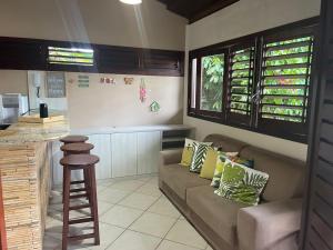 a living room with a couch and a kitchen at Apartamento PIPA - UF01 in Pipa