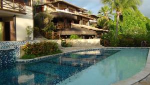 a swimming pool in front of a house at Apartamento PIPA - UF01 in Pipa