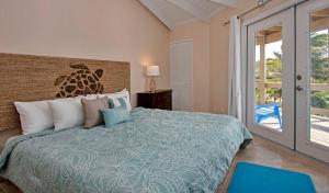 St Francis Resort في جورج تاون: غرفة نوم بسرير وباب زجاجي منزلق