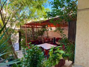 a patio with a table and chairs in a garden at Al-Amer Hostel 1 in Aqaba