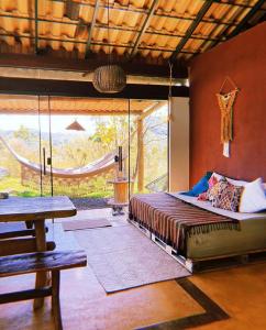 een slaapkamer met een bed in een kamer met een hangmat bij Vila Chappada in Alto Paraíso de Goiás