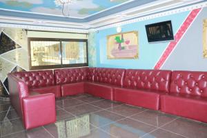 un sofá de cuero rojo en una habitación con paredes azules en DEUDJUI HOTEL, en Bafang