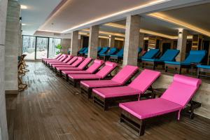 una fila de sillas rosas en una sala de espera en Milmari Apartments FREE SPA & PARKING Kopaonik, en Kopaonik