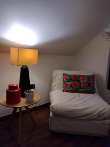 a room with a bed and a table with a lamp at Acogedora Casa con Tinaja y Jacuzzi y RENT A CAR in Puerto Varas