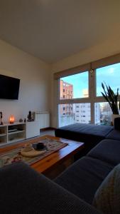 a living room with a couch and a large window at 3 amb en zona Guemes. A pasos del Aldrey y bares. in Mar del Plata