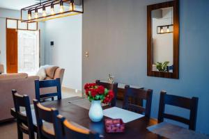 a dining room table with a vase of flowers on it at Encantador y amplio departamento en zona tranquila in Sucre