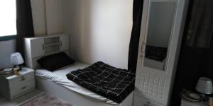 a small room with a bed and a mirror at Masat El Sharjah for men in Sharjah