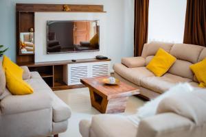 a living room with two couches and a tv at Encantador y amplio departamento en zona tranquila in Sucre