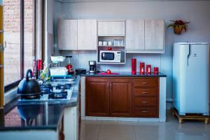 een keuken met een fornuis en een magnetron bij Encantador y amplio departamento en zona tranquila in Sucre