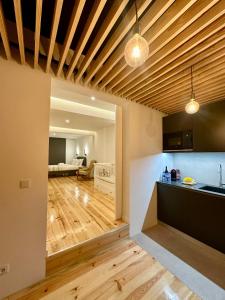 uma cozinha e sala de estar com tecto em madeira em A casa na Estrela em Lisboa