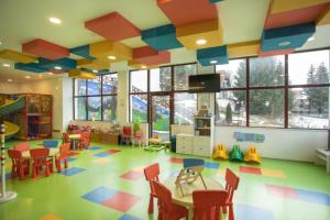 a room with a classroom with colorful floors and a play area at Wolf Apartments Kopaonik in Kopaonik