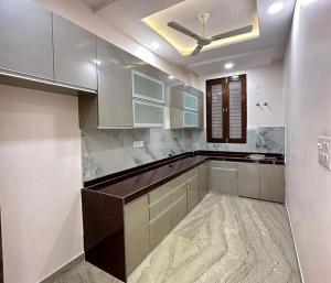 a kitchen with white cabinets and a ceiling fan at FIRSTHOUSE VILLA@BATU FERRINGHI in Batu Ferringhi