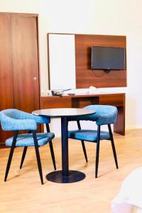 a table and two blue chairs in a room at Safa PARK HOTEL YANBU فندق صفا بارك ينبع in Yanbu