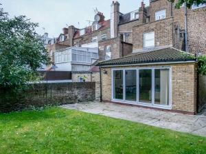 an extension to a brick house with a window at Charming Oasis with Garden in London